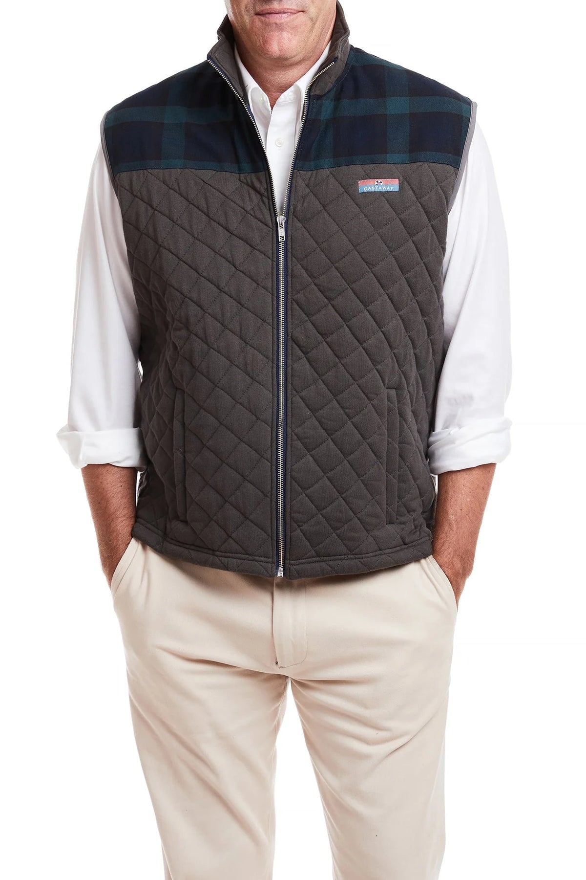 Man wearing cross rip quilted vest with Tartan trim walking on the beach