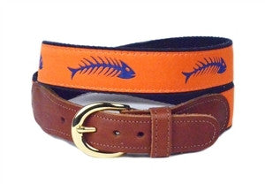 Men's custom canvas ribbon belt with  navy fish bones on an orange background is finished with leather tabs and a brass buckle. 