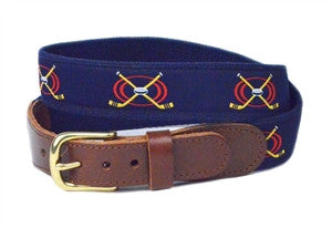 Men' s Hockey ribbon belt is a Designs by Lillie Exclusive.  The image has a repeat of 2 hockey sticks in gold and black in a red circle with a gray and black puck.  The navy woven ribbon is stitched onto navy webbing with a brass buckle and leather tabs.