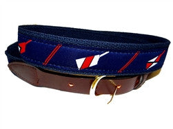 Cool crew ribbon belt with red and white oar blades on a navy background. Finish wityh leather tabs and a brass buckle. A Design by Lillie Exclusive