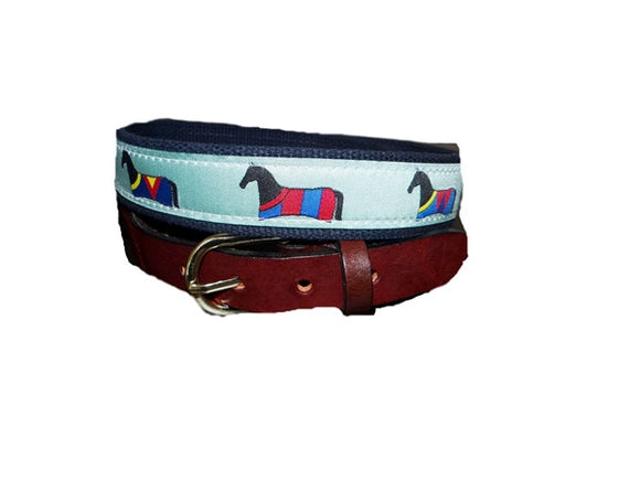 The Horse Blanket ribbon belt for men is a Lillie Design Exclusive.  The blankets covering the horses have unique patterns with colors that pop. The pattern is woven on a mint color ribbon and finished with leather tabs and a brass buckle. 