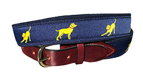 Man's best friend is the yellow lab. The navy ribbon with the yellow pup is stitched onto navy webbing and completed with leather tabs and a brass buckle.  Exclusive. Sizes 30-54
